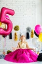 Cute little girl with dark hair, in a fancy dress and balloons for her birthday. Child 5 years old Royalty Free Stock Photo