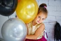 Cute little girl with dark hair, in a fancy dress and balloons for her birthday. Child 5 years old Royalty Free Stock Photo