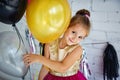 Cute little girl with dark hair, in a fancy dress and balloons for her birthday. Child 5 years old Royalty Free Stock Photo