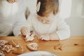 Cute little girl decorating christmas gingerbread cookies with icing on wooden table, close up. Happy family time together, Royalty Free Stock Photo