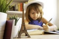 Cute little girl doing homework in her bedroom at the desk - Child girl writing in her diary imagining a trip to Paris - Childhood Royalty Free Stock Photo