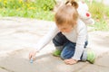 Cute little girl drawing with blue chalk