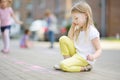 Cute little girl drawing with colorful chalks on a sidewalk. Summer activity for small kids. Royalty Free Stock Photo