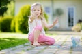 Cute little girl drawing with colorful chalks on a sidewalk. Summer activity for small kids. Royalty Free Stock Photo