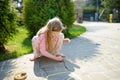 Cute little girl drawing with colorful chalks on a sidewalk. Summer activity for small kids Royalty Free Stock Photo