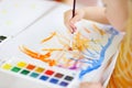 Cute little girl drawing with colorful paints at a daycare. Creative kid painting at school.