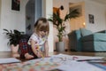 Cute little girl drawing with crayons, sitting on the floor at home. Royalty Free Stock Photo