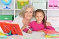 Cute little girl drawing with her grandmother Royalty Free Stock Photo