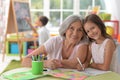 Cute little girl drawing with her grandmother Royalty Free Stock Photo