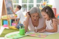 Cute little girl drawing with her grandmother Royalty Free Stock Photo