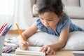 Cute little girl drawing homework and writing with pen on paper in her home Royalty Free Stock Photo