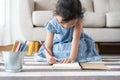 Cute little girl drawing homework and writing with pen on paper in her home Royalty Free Stock Photo