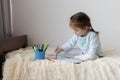 cute little girl drawings sitting on bed.