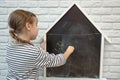 Cute little girl draws with chalk on the blackboard Royalty Free Stock Photo