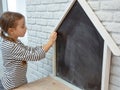 Cute little girl draws with chalk on the blackboard Royalty Free Stock Photo