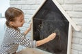 Cute little girl draws with chalk on the blackboard Royalty Free Stock Photo