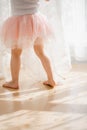 Cute little girl dreams of becoming a ballerina. Child in a pink tutu dancing in a kids room Royalty Free Stock Photo