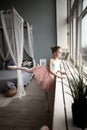 Little girl dreams of becoming a ballerina. Child in a pink tutu dancing in a kids room. Royalty Free Stock Photo