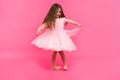 Cute little girl dreams of becoming a ballerina. Little Dancing Girl. Studio Shoot Over Pink Background Royalty Free Stock Photo