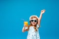 Cute little girl in a dress, hat and sunglasses poses on a pink background Royalty Free Stock Photo