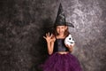 Cute little girl dressed as witch for Halloween near dark wall Royalty Free Stock Photo