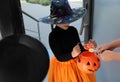 Cute little girl dressed as witch trick-or-treating at doorway. Halloween