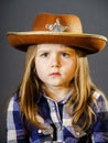 Cute little girl dressed in cowboy shirt and sheriff hat Royalty Free Stock Photo