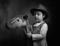 Cute little girl dressed like a cowboy playing with a homemade h Royalty Free Stock Photo