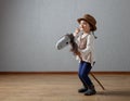 Cute little girl dressed like a cowboy playing with a homemade h Royalty Free Stock Photo