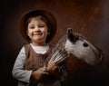 Cute little girl dressed like a cowboy playing with a homemade h Royalty Free Stock Photo