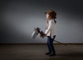 Cute little girl dressed like a cowboy playing with a homemade h Royalty Free Stock Photo