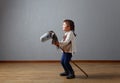 Cute little girl dressed like a cowboy playing with a homemade horse Royalty Free Stock Photo