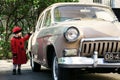 Cute little girl dressed in retro coat posing near oldtimer car Royalty Free Stock Photo