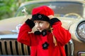 Cute little girl dressed in retro coat posing near oldtimer car Royalty Free Stock Photo