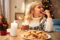 Cute little girl drinking cacao and eating cookie at home Royalty Free Stock Photo