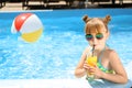 Cute little girl drinking juice in swimming pool Royalty Free Stock Photo