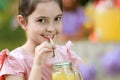 Cute little girl drinking natural lemonade in park, closeup with space for text. Summer refreshing Royalty Free Stock Photo