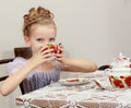 Cute little girl drinking tea at the old table. Royalty Free Stock Photo