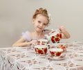 Cute little girl drinking tea at the old table. Royalty Free Stock Photo