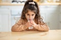 Cute Little Girl Drinking Water From Glass, Sitting At Table In Kitchen Royalty Free Stock Photo