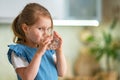 Cute little girl drinking water in kitchen at home. Water balance Royalty Free Stock Photo