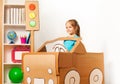 Cute little girl driving her toy cardboard car Royalty Free Stock Photo