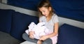 Cute little girl eading a book with stuffed teddy bunny toy