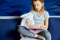 Cute little girl eading a book with stuffed teddy bunny toy Royalty Free Stock Photo