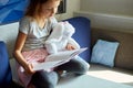 Cute little girl eading a book with stuffed teddy bunny toy