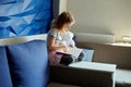 Cute little girl eading a book with stuffed teddy bunny toy