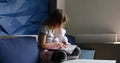 Cute little girl eading a book with stuffed teddy bunny toy