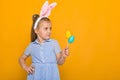 Cute little girl with Easter bunny ears holding colorful eggs Royalty Free Stock Photo