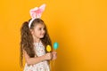 Cute little girl with Easter bunny ears holding colorful eggs Royalty Free Stock Photo