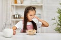 Cute little girl eating breakfast: cereal with the milk Royalty Free Stock Photo